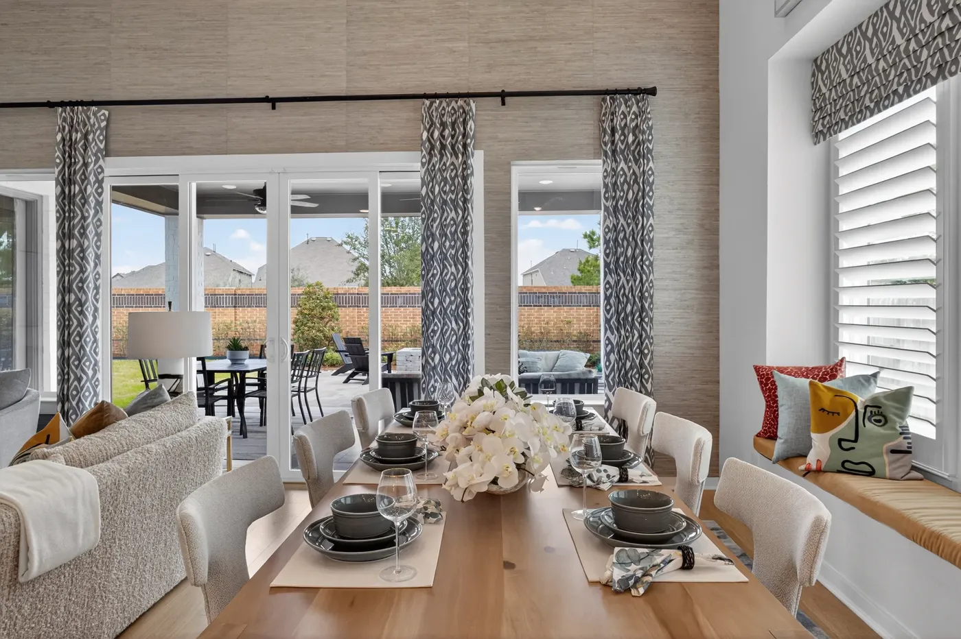 Dining room with a set table beside tall windows