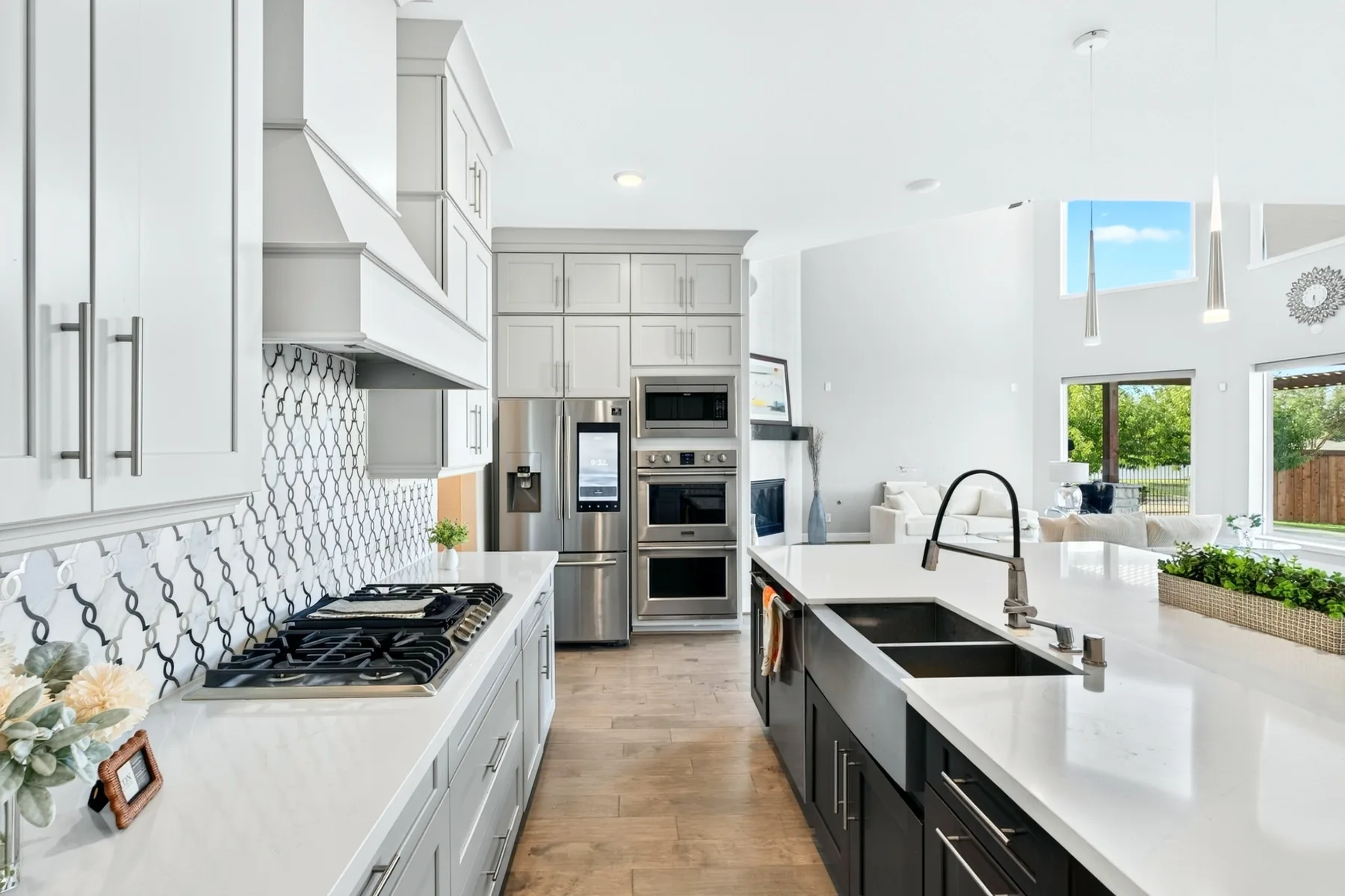 White kitchen with a statement island, gas cooktop and stainless appliances